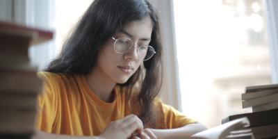 A student studying surrounded by books