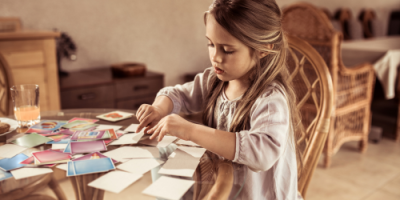 Girl sitting at a table looking at photographs