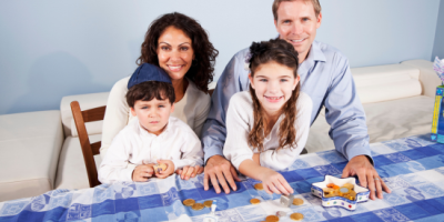 A Jewish family sitting at a table smiling