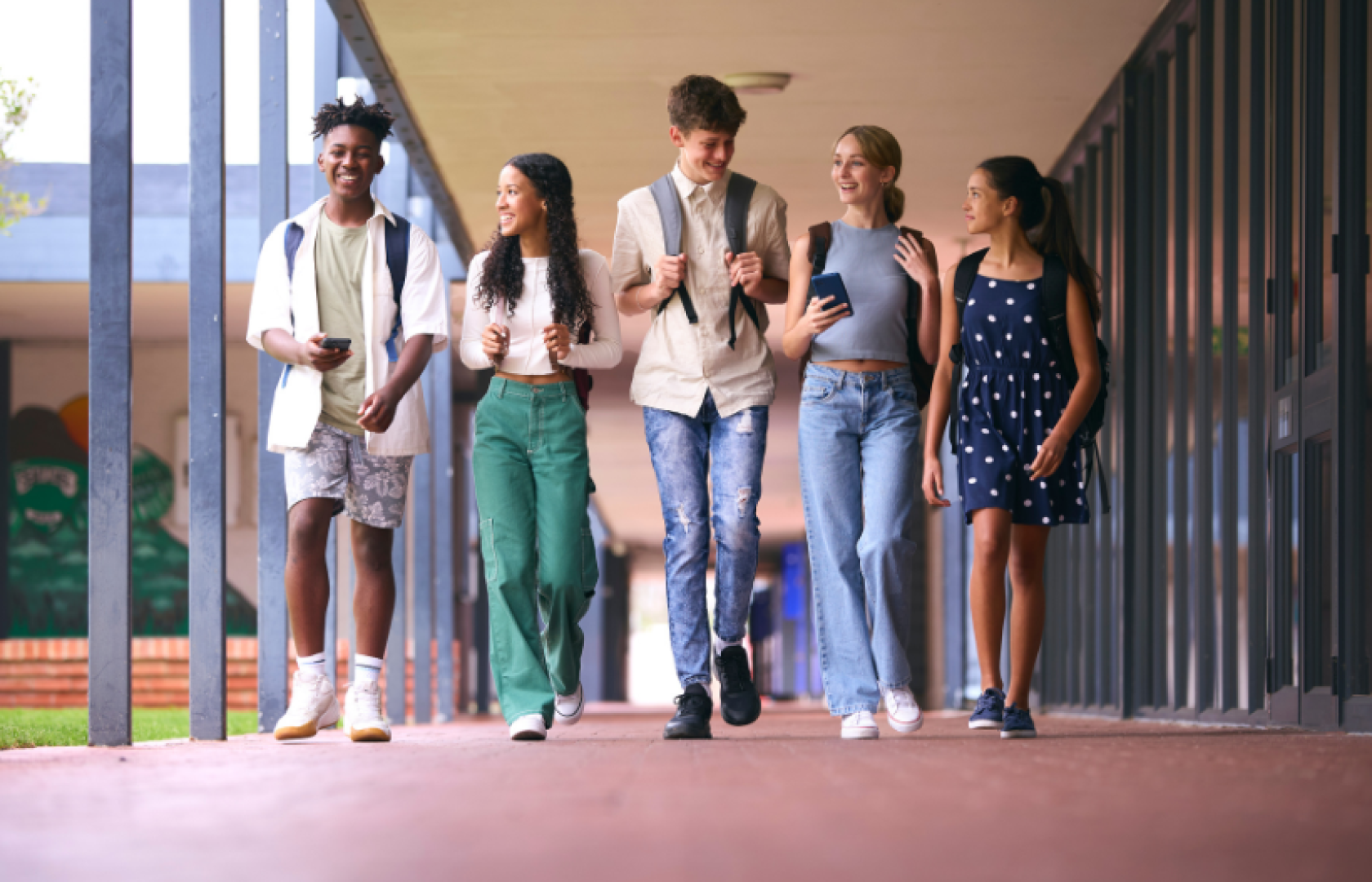 A group of teens walking through school smiling