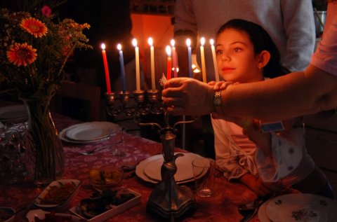 Girl lighting a Chanukkiah