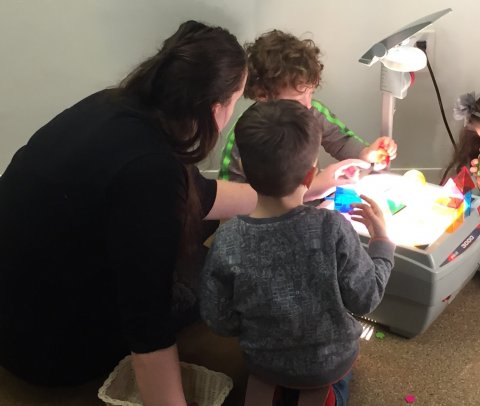 Brotherhood Synagogue teacher and kids beside light