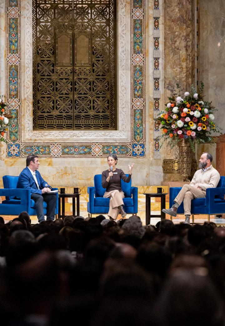 Three people on stage with an audience