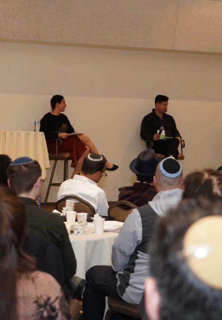 a panel of three people in front of a crowd