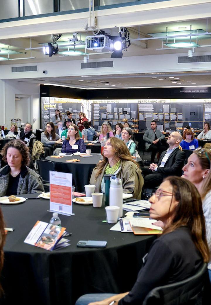 a group of educators sitting around a table covered in black tablecloth at a conference