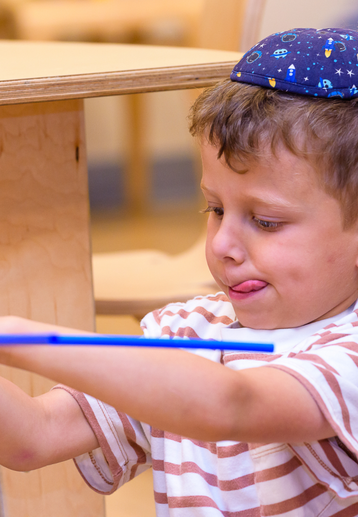 boy with kippah builds a toy