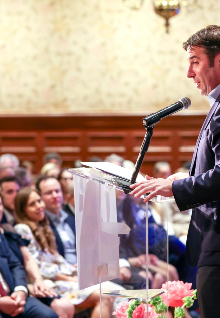David speaking at podium in front of room of people
