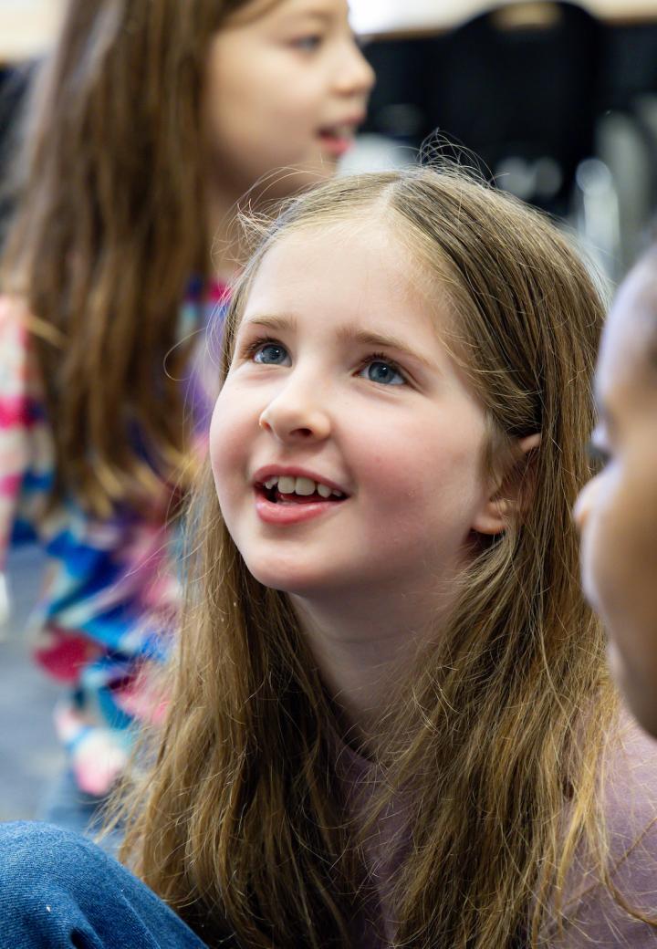 a young girl looks up smiling