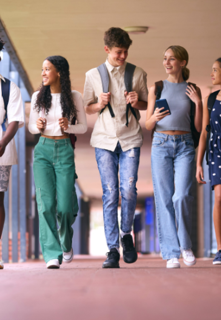 A group of teens walking through school smiling