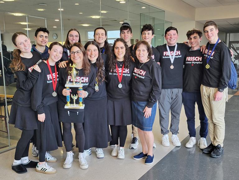 a group of orthodox teens smile and pose with trophies