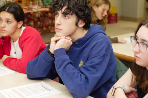 Teens sit in a classroom and look thoughtful