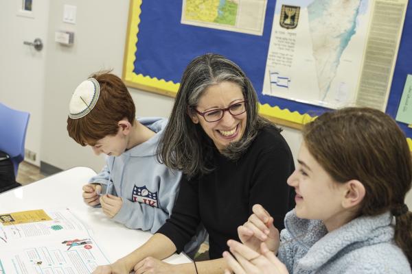 a teacher in a classroom sitting with a girl student