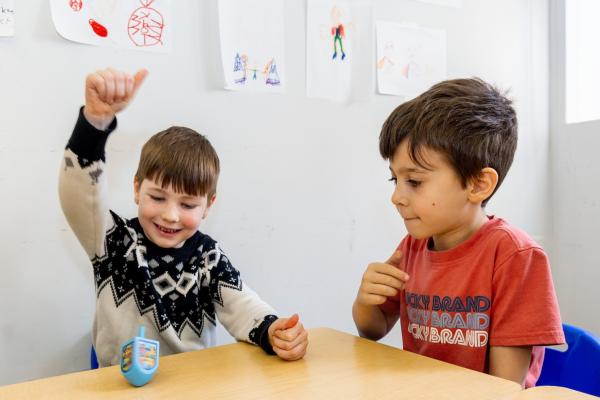 two boys play dreidel