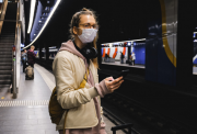 Woman in a train station with a Facemask